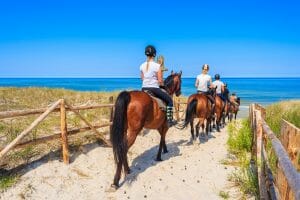 A horseback rider exploring a sandy beach during sunset in Naxos.